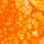 オレンジの流体に泡が広がるクローズアップ
