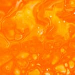 オレンジ色の液体が泡立つ抽象的な質感